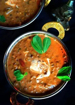 Dal makhani in a copper bowl with fresh herbs